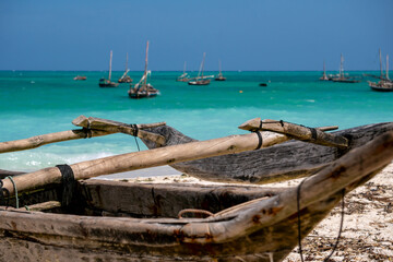 Fototapeta premium Traditional wooden dhow boats on the White Sand Beach with amazing turquoise water in the Indian ocean at Nungwi village, Zanzibar, Tanzania