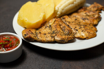 plato suculento de pollo a la plancha con choclo, papas sancochadas y rocoto