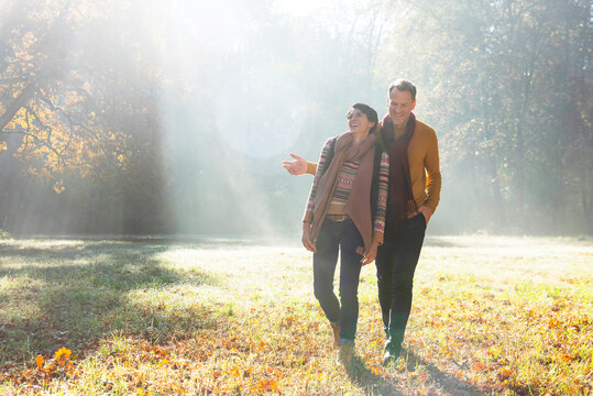 Couple walking in autumnal park, Strandbad, Mannheim, Germany