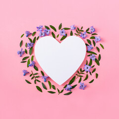 Hyacinth flowers and green leaves on a pink background. Heart empty frame for text