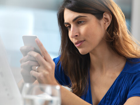 Woman Using Mobile Phone In Office