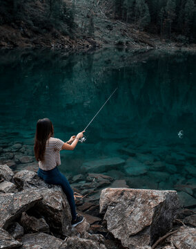 Woman fishing in lake, Antronapiana, Piemonte, Italy