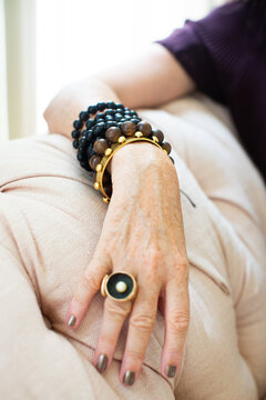 Stylish mature woman wearing bead bracelets and ring, close up of hand
