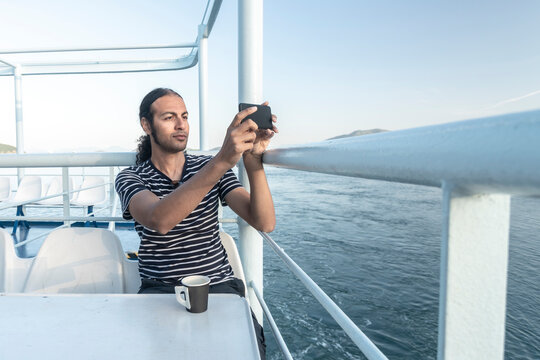 Man on cruise boat taking photograph