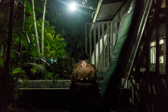 Man texting by wooden building, Abulug, Cagayan, Philippines