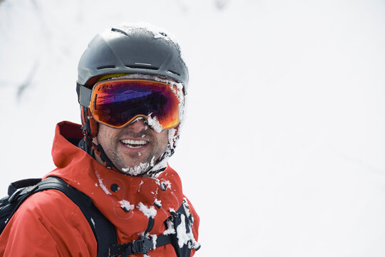 Male skier in ski helmet and goggles with frosty beard, portrait, Alpe-d'Huez, Rhone-Alpes, France