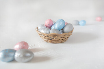 on a white background there is a small basket of eggs, colorful eggs, shiny eggs, side view, Easter corosinka, Easter basket with eggs, light background, 
