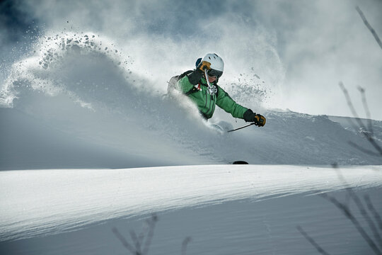 Male skier skiing on snow covered mountain, Alpe-d'Huez, Rhone-Alpes, France