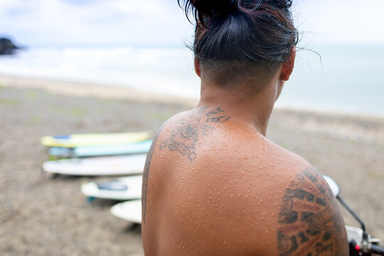 Man looking at surfboards on beach, Pagudpud, Ilocos Norte, Philippines