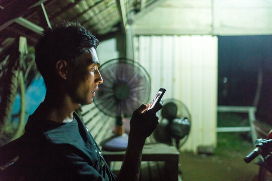 Man texting by fans, Abulug, Cagayan, Philippines