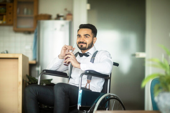 Businessman having drink in wheelchair
