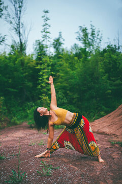 Woman doing triangle pose in forest