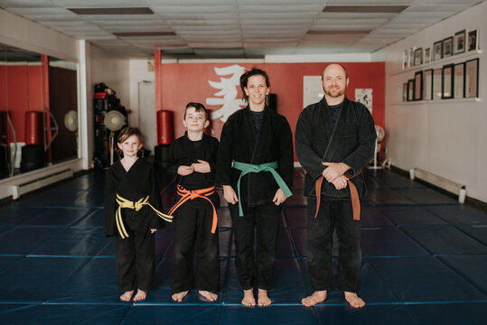 Coaches and students posing in martial arts studio