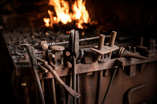 Row of tools in front of fire in blacksmiths workshop