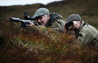 Man and gamekeeper deer stalking on moorland, Scottish Highlands