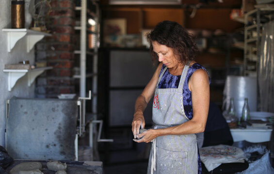 Female potter shaping clay in workshop