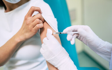 Covid-19 or coronavirus vaccine doctor holding syringe and using cotton before making injection to...