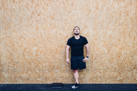 Man with disability leaning against chipboard wall