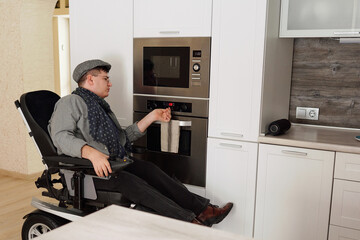 Physically impaired man switching on oven in kitchen