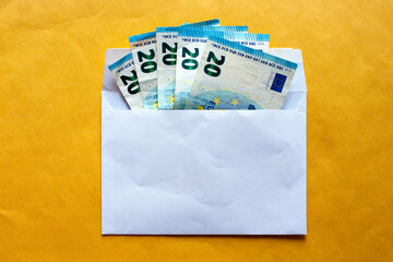 envelope  with 20euro banknotes in, on yellow background