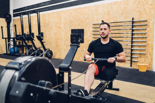Man with disability using rowing machine in gym
