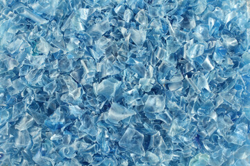 A heap of small pieces of chopped blue plastic bottles. View from above. Closeup