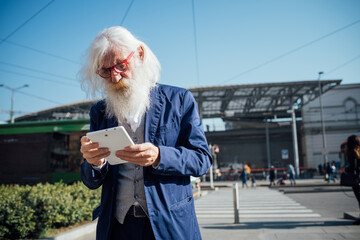 Senior businessman using digital tablet at bus terminal, Milano, Lombardia, Italy