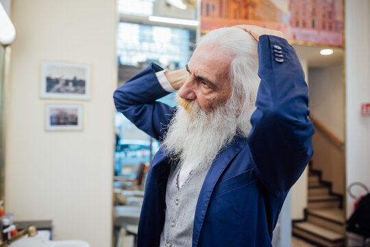 Senior businessman combing hair in salon