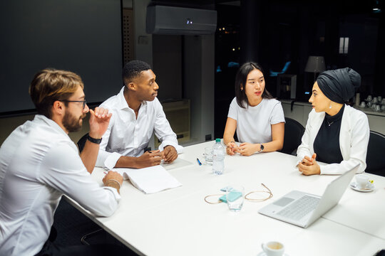 Businessmen and women having discussion during conference table meeting