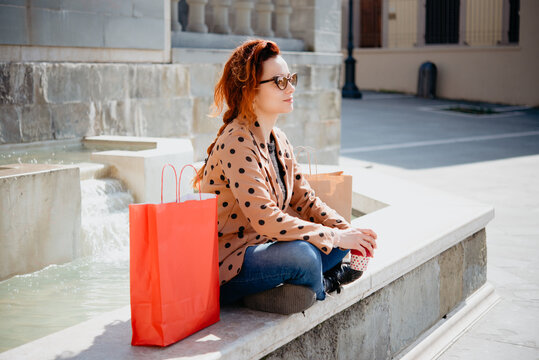 Female shopper taking break in front of fountain, Arezzo, Toscana, Italy