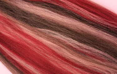 Naklejka premium Bright synthetic hair for weaving different hairstyle, braids, dreadlocks, afro braids. Pink and red Kanekalon