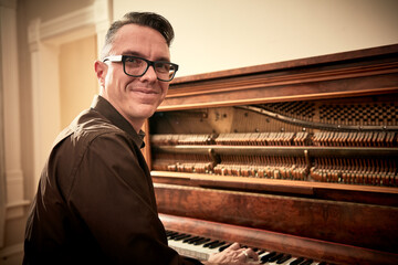 Man smiling and playing piano