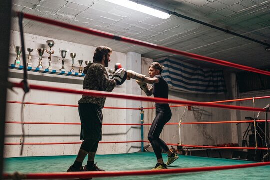  Boxer sparring with trainer in boxing ring