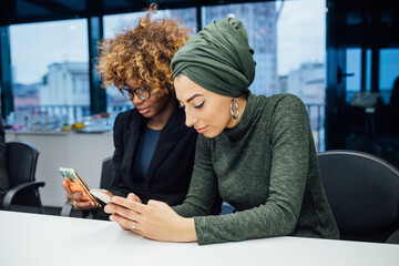 Business partners using smartphone at meeting in office