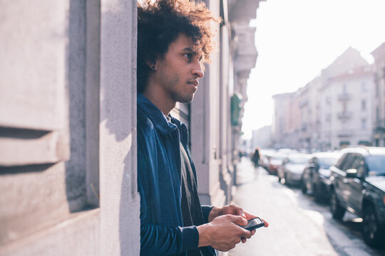 Young man using smartphone on pavement, Milano, Lombardia, Italy