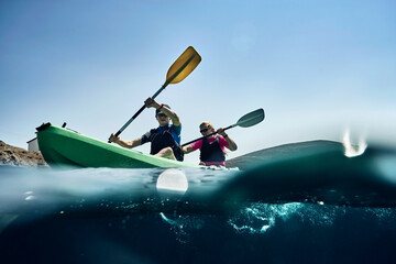 Teenage boy and mother sea kayaking on ocean, surface level view, Limnos, Khios, Greece