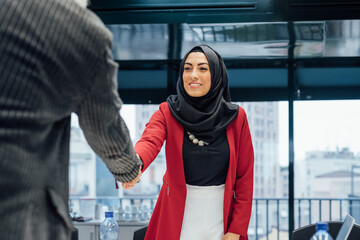 Business partners shaking hands at meeting in office