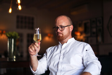 Portrait of chef with glass of wine in luxury restaurant