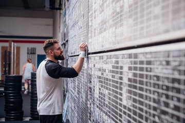 Young man writing on scoreboard in gym
