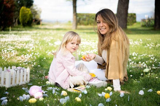 Mother and daughter relaxing in wildflower field after easter egg hunt, portrait, Arezzo, Tuscany, Italy