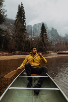 Young male canoeist rowing canoe on river, Yosemite Village, California, USA