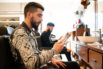 Customers waiting and reading in barber shop