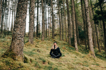 Trekker meditating in forest, Trossachs National Park, Canada