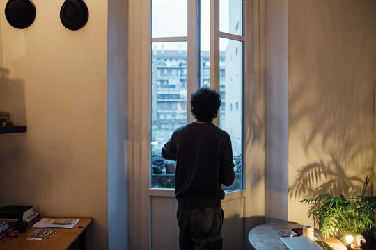 Man looking out of house window