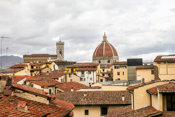 Fototapeta na wymiar Roofs of houses and buildings with the dome in the background in Florence, Italy.
