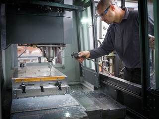 Knife factory worker operating cutting machinery