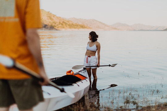 Woman beside kayak in lake, Kaweah, California, United States