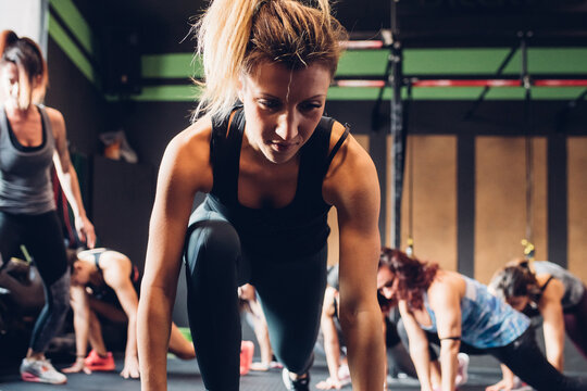Women training in gym, leaning forward stretching