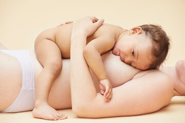 Naked baby sucking naked mother's breast