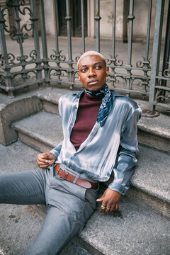 Stylish man sitting on steps of period building, Milan, Italy